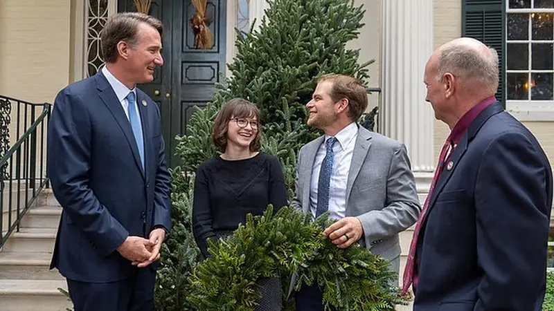 Governor Youngkin talking with the farm’s owners on the Executive Mansion steps, the wreath between them (official photo)