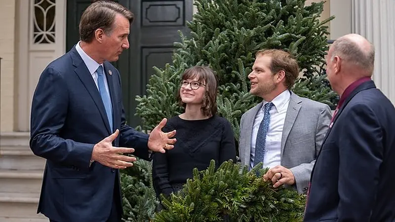 The Governor, hands mid-gesture, in conversation with the owners beside the mansion’s front door (official photo)
